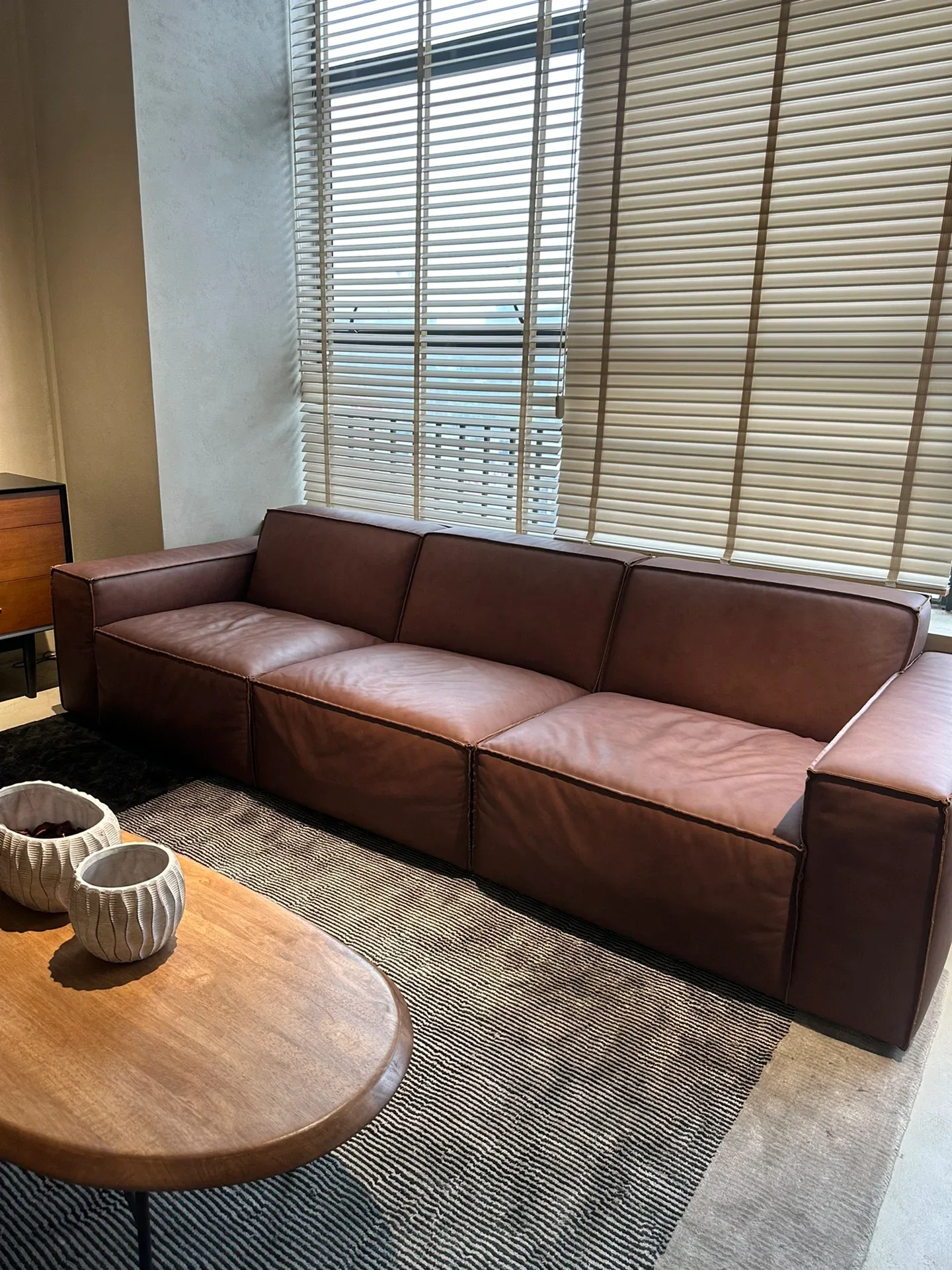 A deep three-seat leather sofa in the same showroom. Upholstery like this takes a lot of container volume for its value, which is why the sofa list.