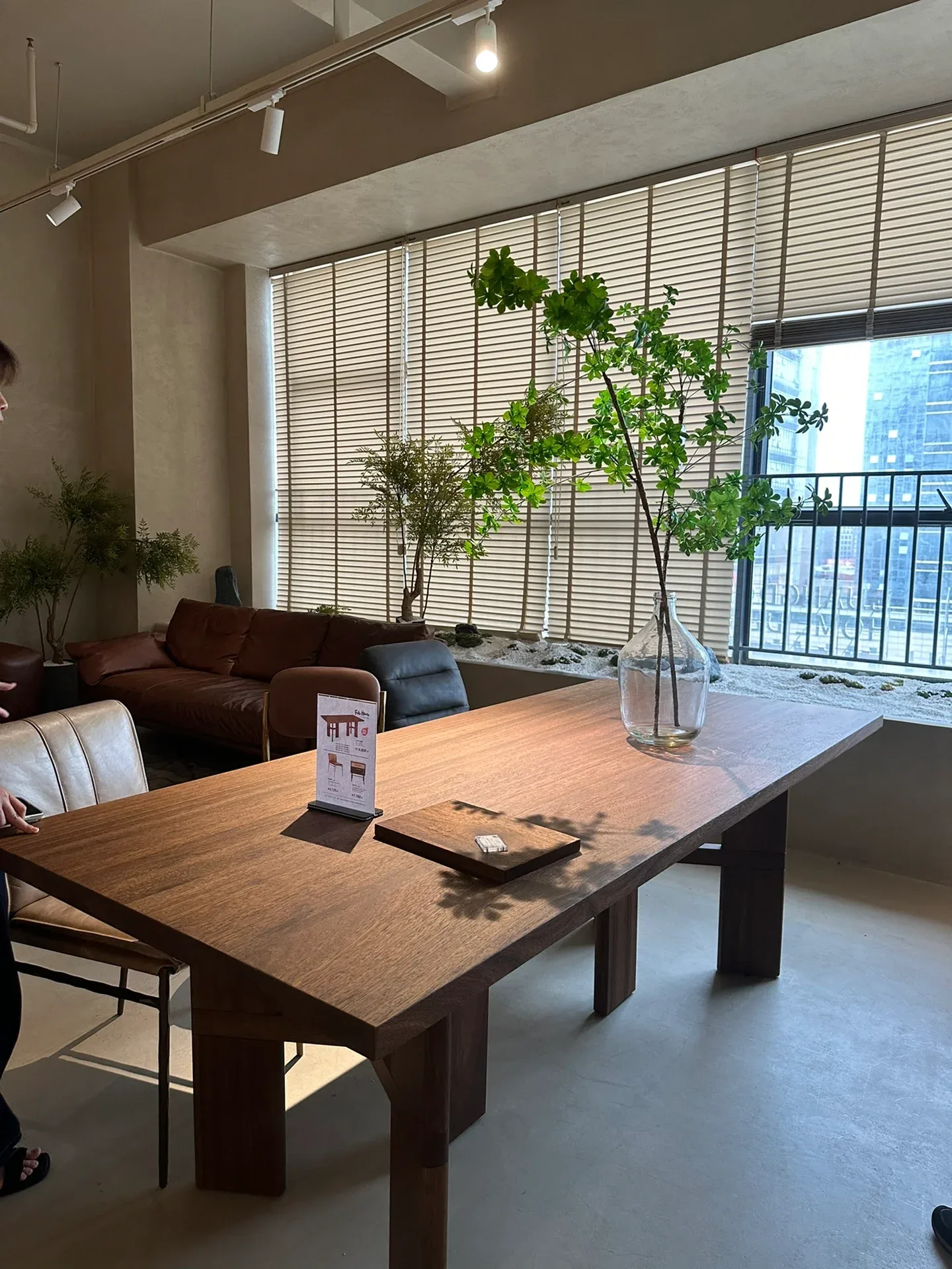 A solid-wood dining table with a price card on it, in a vintage-style Foshan showroom. Showroom prices are a starting point; the factory price, fee.
