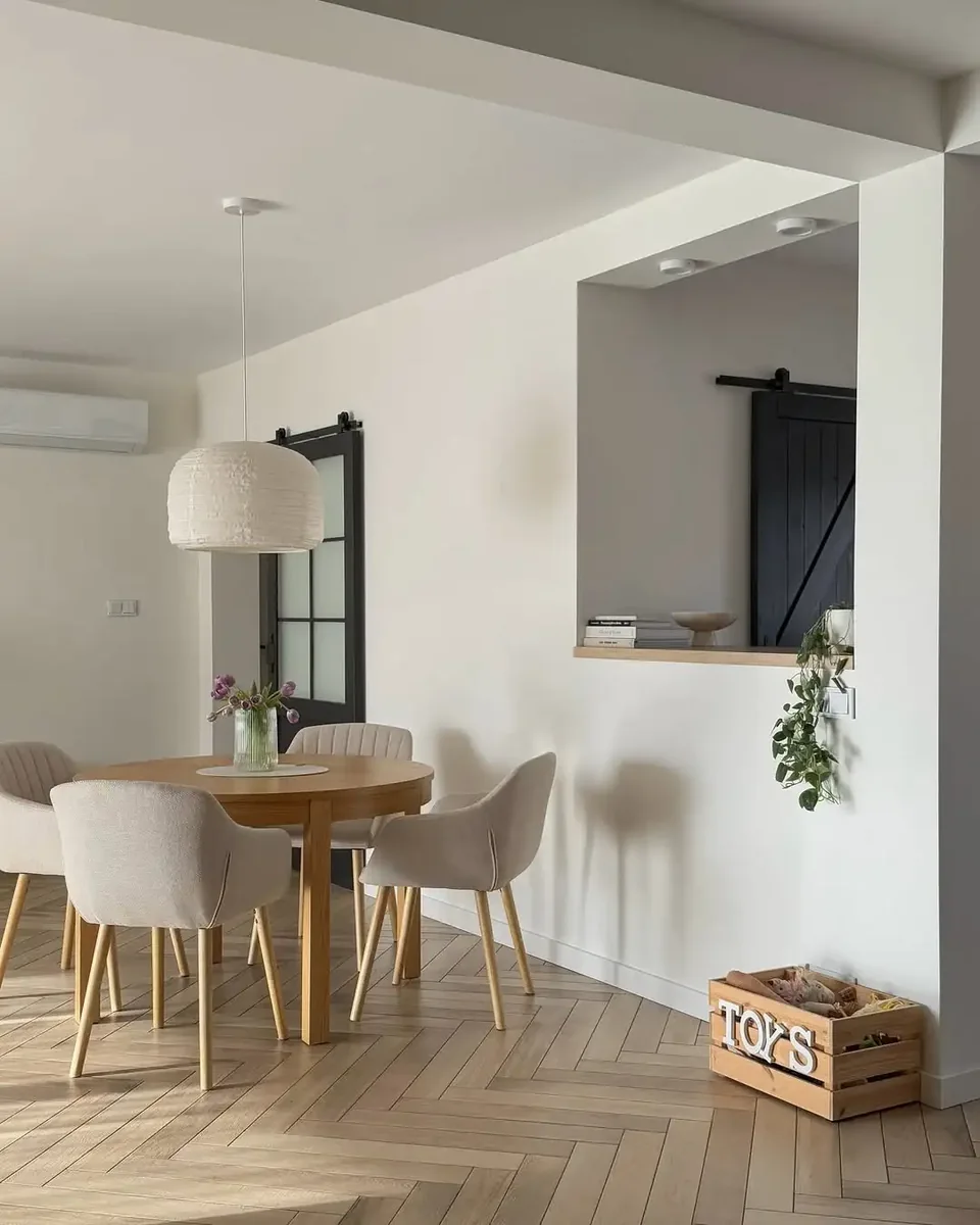 Round dining table with light upholstered chairs