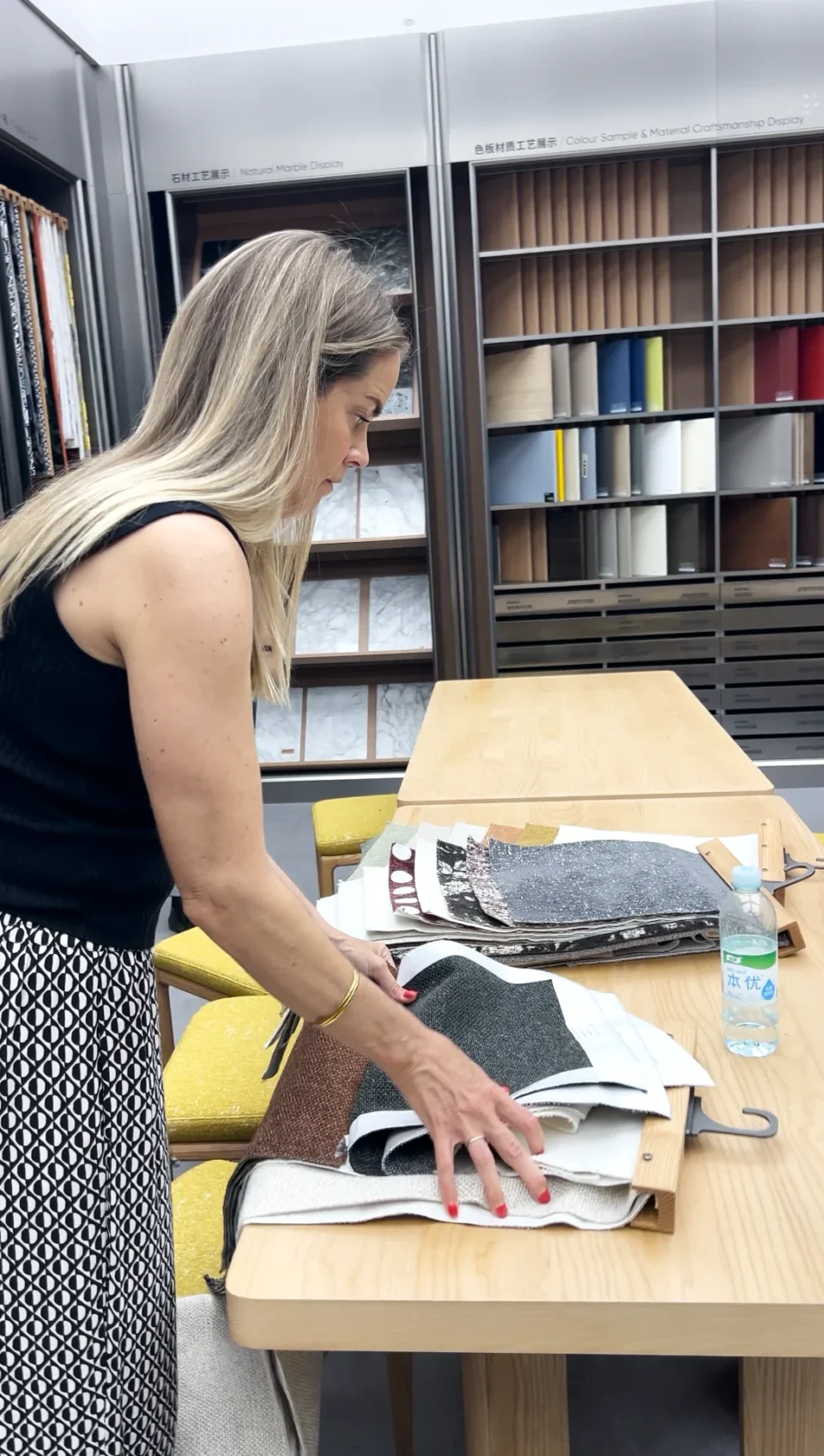 An Australian buyer looking through fabric samples on a showroom table.