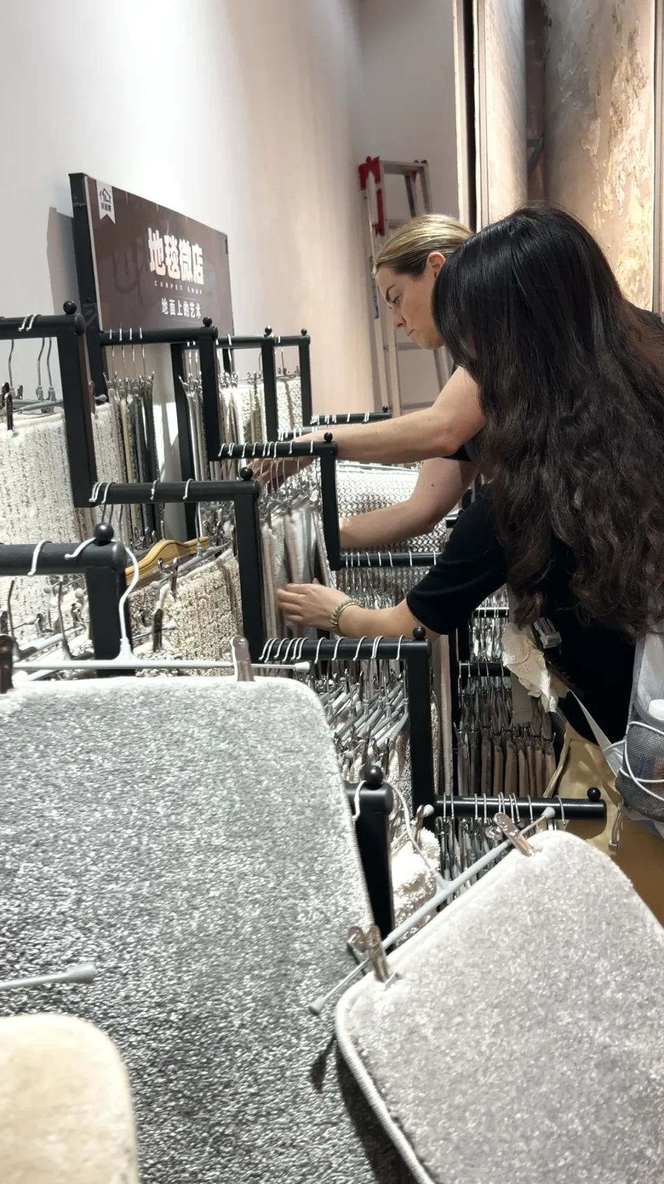 A buyer and guide examining rug samples in a showroom.