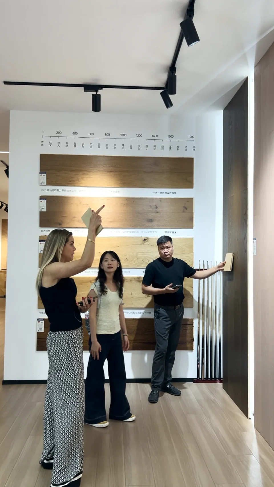 A buyer and showroom staff discussing timber flooring displays.