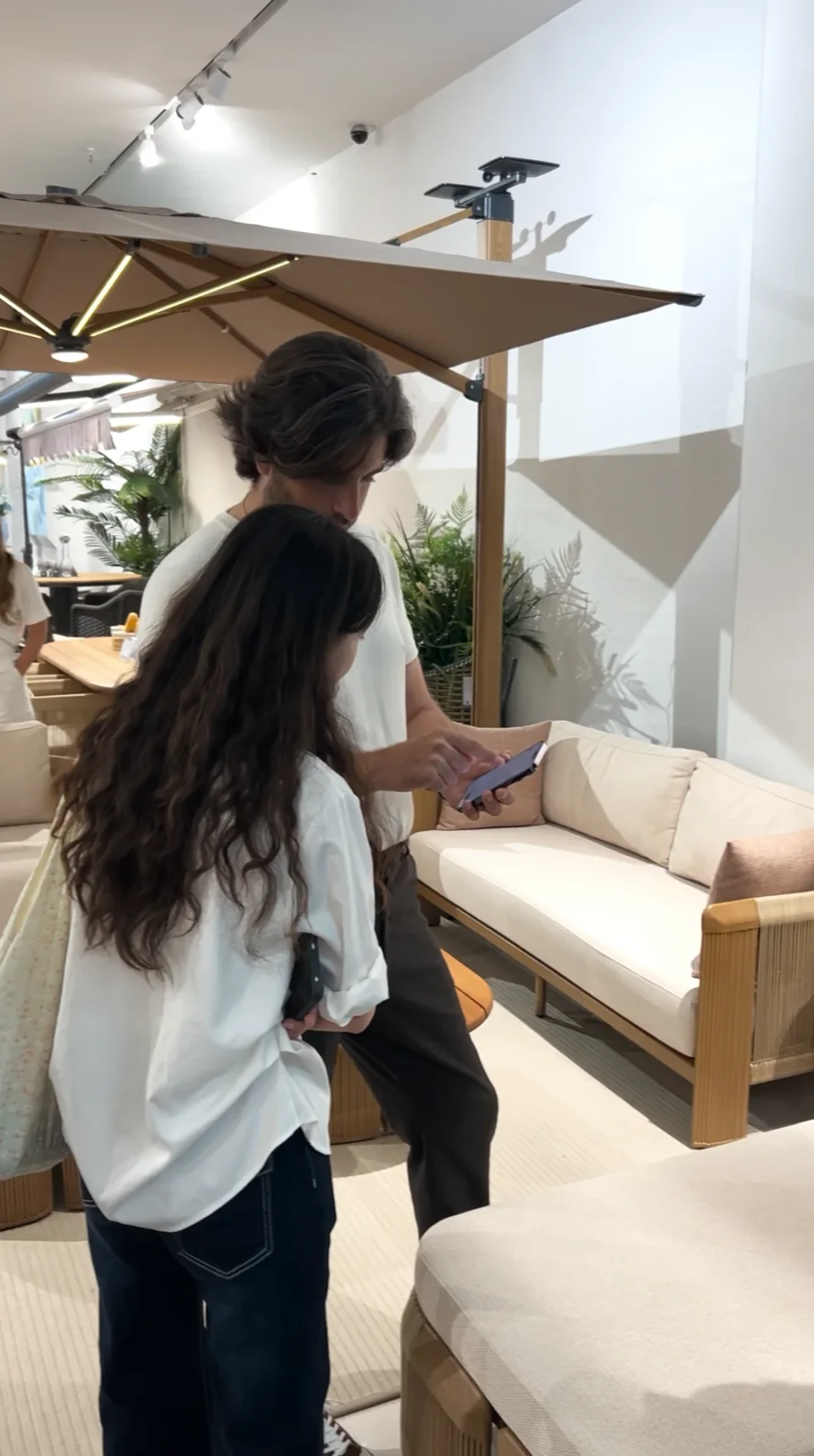 A guided discussion beside an outdoor-style sofa display.