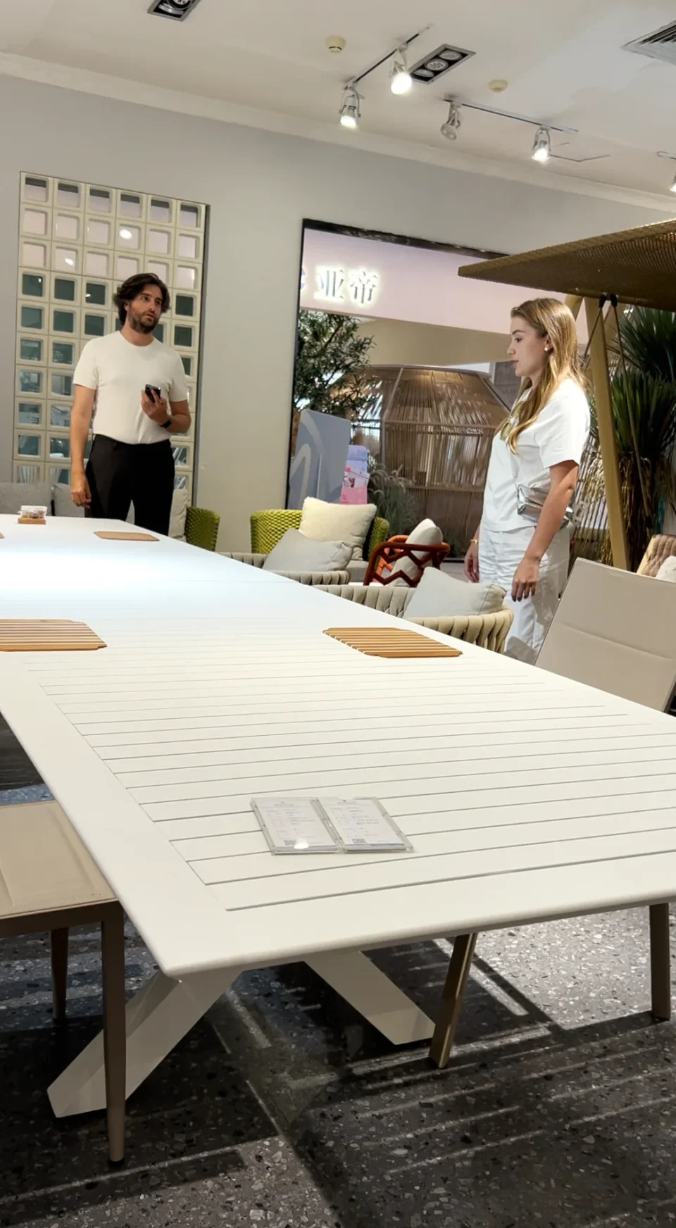 Buyers and showroom staff discussing a large slatted table.