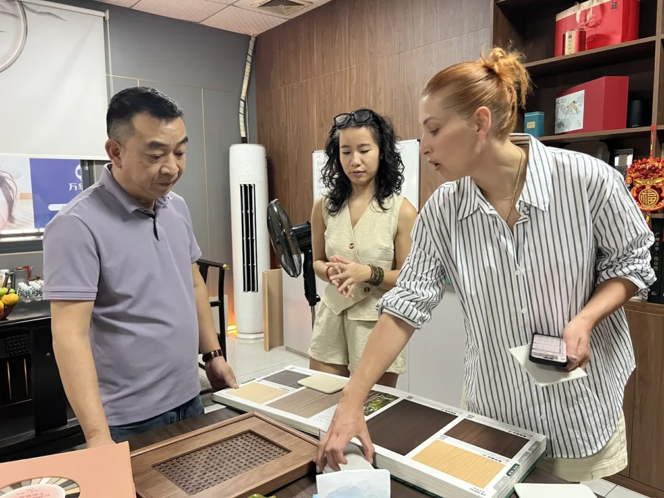 A group comparing cabinet finish samples arranged on a table.